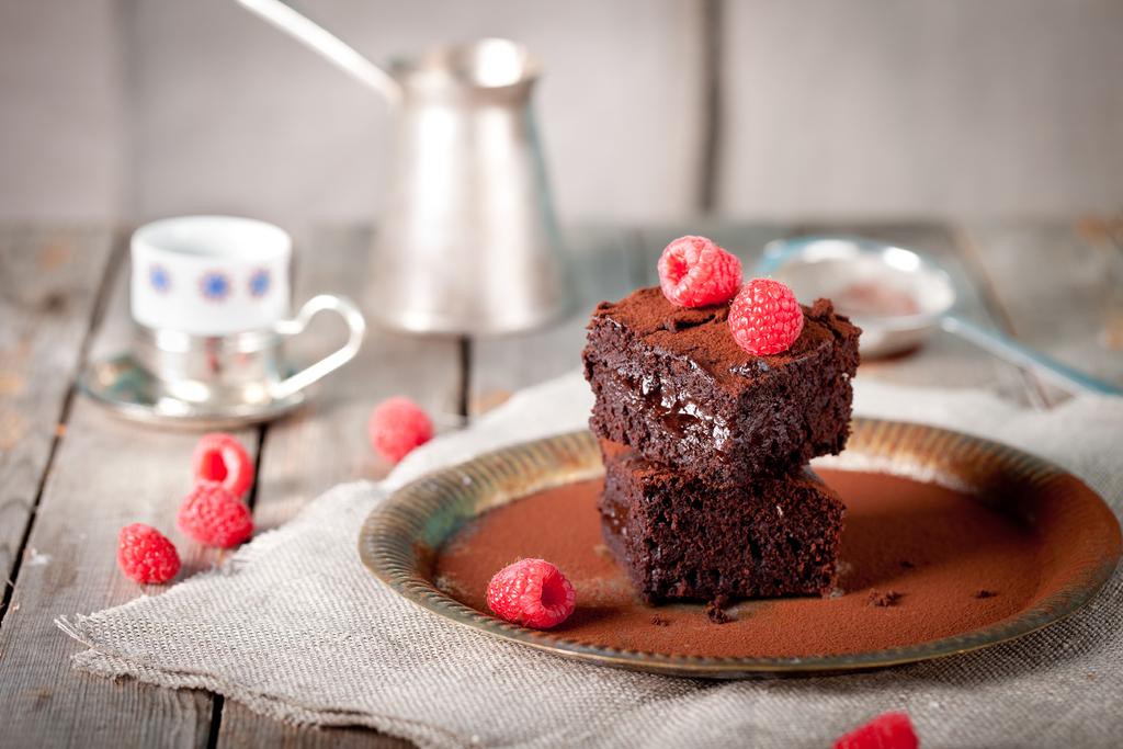 Brownies with raspberry on a wooden background. - Peugeot Saveurs